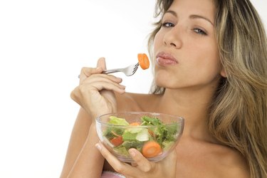 Young woman eating salad