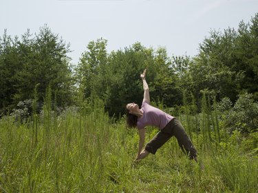 Mature woman stretching on meadow