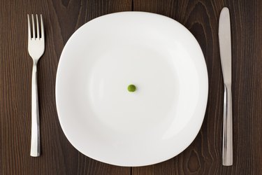 One pea on a white plate