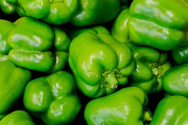 Horizontal picture of a pile of green bell peppers