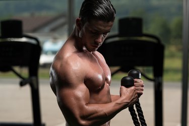 Young Man Doing Heavy Weight Exercise For Biceps