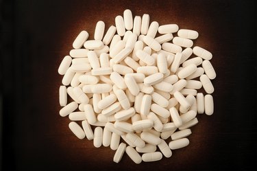 calcium tablets on wooden background