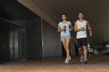 Young couple jogging in building complex