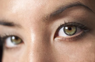 a close up shot of a the beautiful green eyes of a young attractive ethnic girl