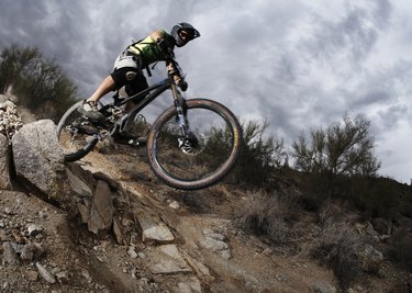 Man mountain biking down steep rocky path, low angle view