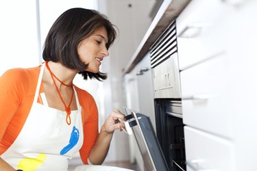 Woman opening the kitchen oven