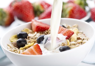 pouring milk into bowl of cereals