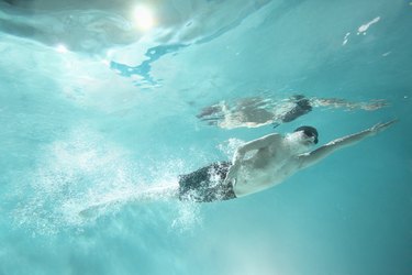 Young swimmer without leg swimming, underwater