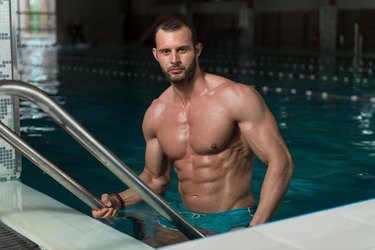 Happy Attractive Man Resting Relaxed On Edge Of Swimming Pool