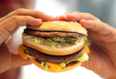 A man’s hands holding a burger.