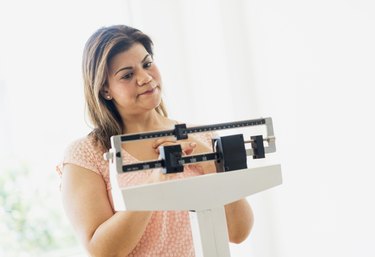 USA, New Jersey, Jersey City, Woman standing on scale