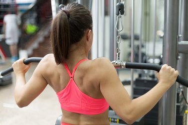 A woman lifts weights in a gym.