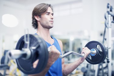 Man lifting barbell in gymnasium