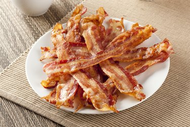 Cooked crispy bacon on white plate