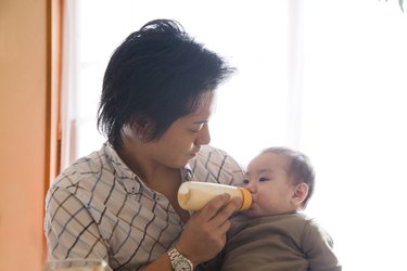 Father Bottle-feeding Baby Girl