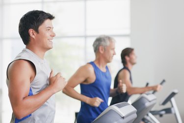 Men running on treadmills in gymnasium