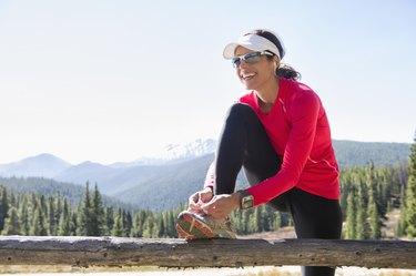 Hispanic runner tying her shoelaces
