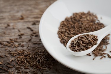 Cumin or caraway seeds on wooden board