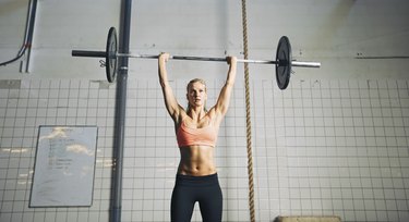 Fitness woman lifting barbells