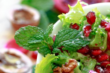 Close up of curly endive salad with pomegranate, nuts...