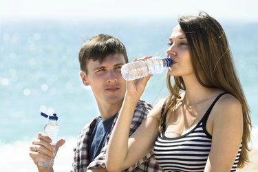 游客在海滩上喝冷水