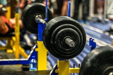 Barbells set up for a bench press in a gym.