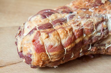Roast meat lies on a wooden board