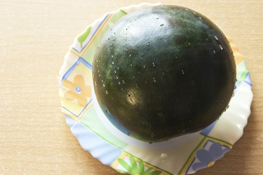 Fresh watermelon on the plate at wooden background