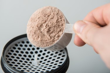 man hand with jar and bottle preparing protein shake