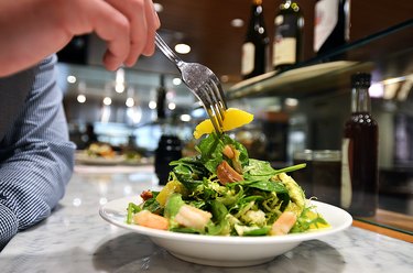 Man Enjoying Hand Tossed Salad with Oranges and Fresh Shrimp