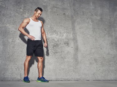 Male fitness model in white tank top after workout