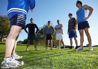 Coach talking to five men in park, low angle view
