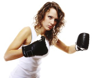 Fit woman boxing - isolated over white