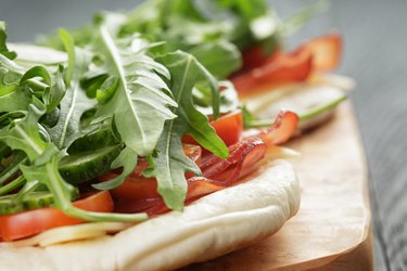 rustic sandwiches with ham arugula and tomatoes in pita bread