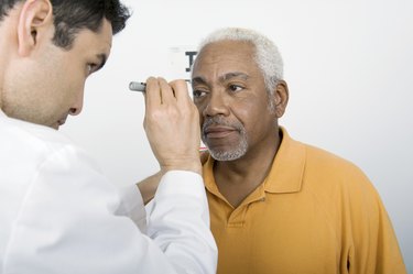 Male Doctor Testing Patient's Eye In Clinic