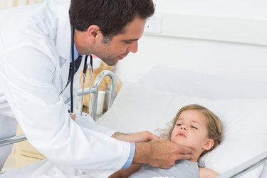 Doctor checking thyroid glands of sick girl