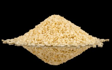 White sesame seeds on black reflective surface