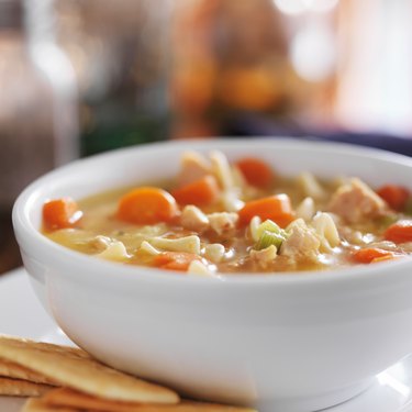 chicken noodle soup with crackers close up