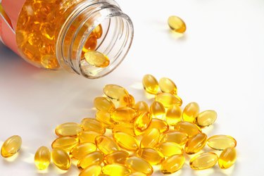 Cod liver oil capsules spilling from container