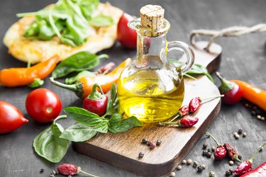 Olive Oil with Spices and Herbs on Wooden Board