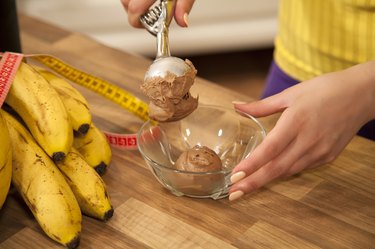 Serving chocolate ice cream into a bowl.