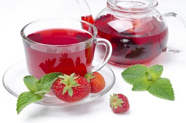 kettle and cup of red tea with strawberries, mint