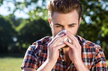 Handsome hipster blowing his nose