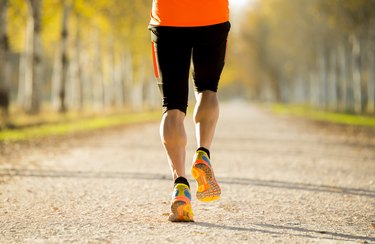 sport man legs with strong calves muscle running off road