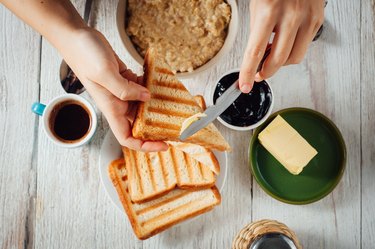 男人的手吃面包当早餐