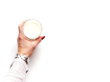Cropped Hand Holding Glass of soylent Against White Background