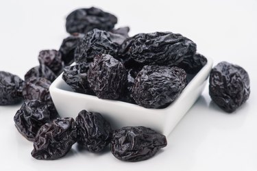 lot of prunes in transparent glass bowl