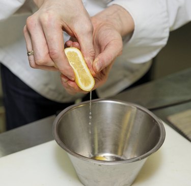 Chef is adding lemon juice in sauce