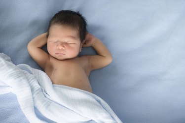 Newborn baby sleeps on blue blankets