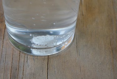 antacids in water glass on wooden table
